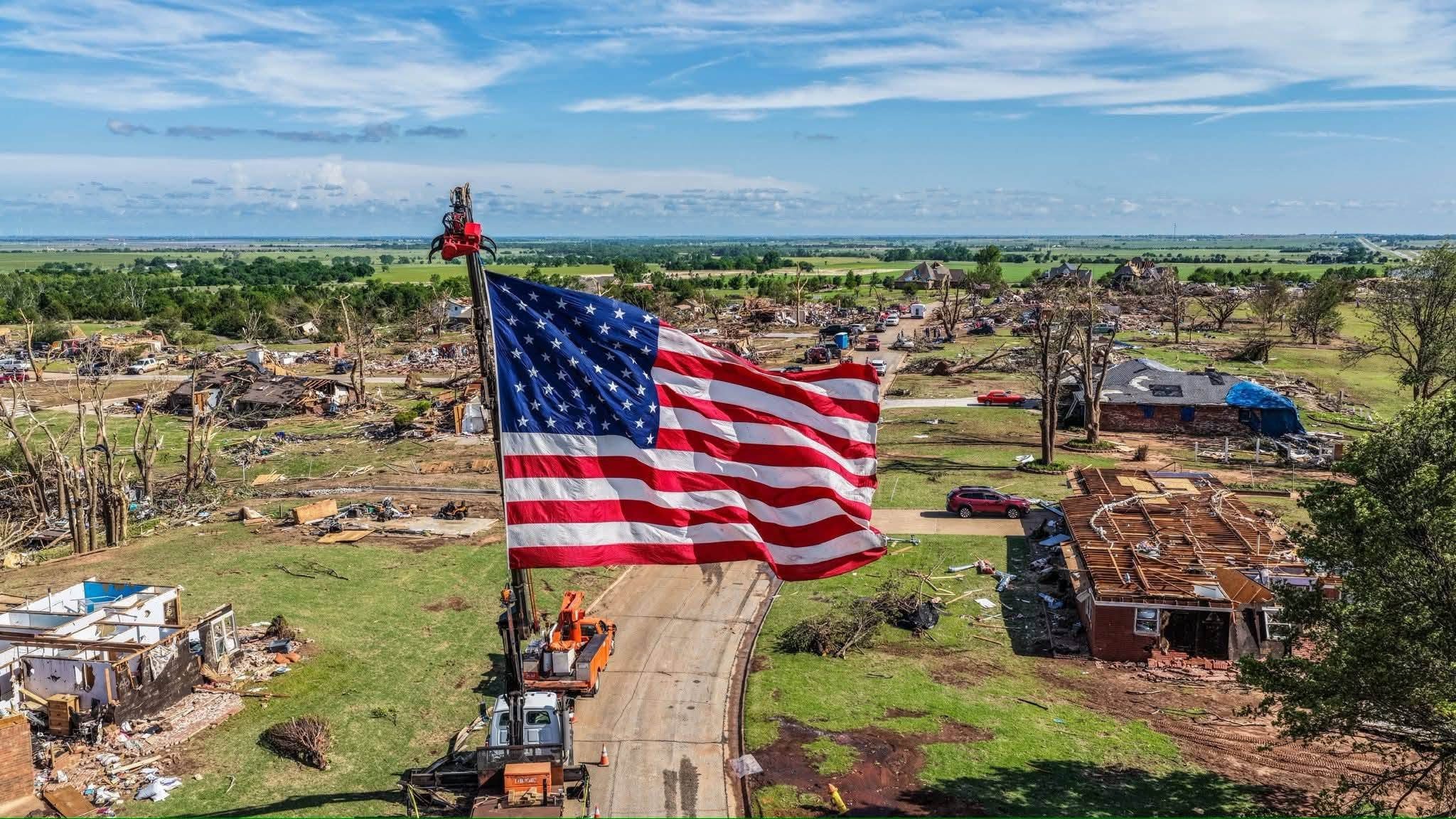 Aerial view of Jennings’ Tree Service flying a large American flag above a tornado-damaged neighborhood.